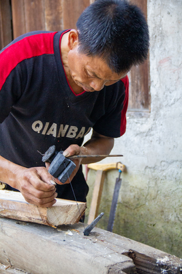 carpenter chiseling traditional wooden beams