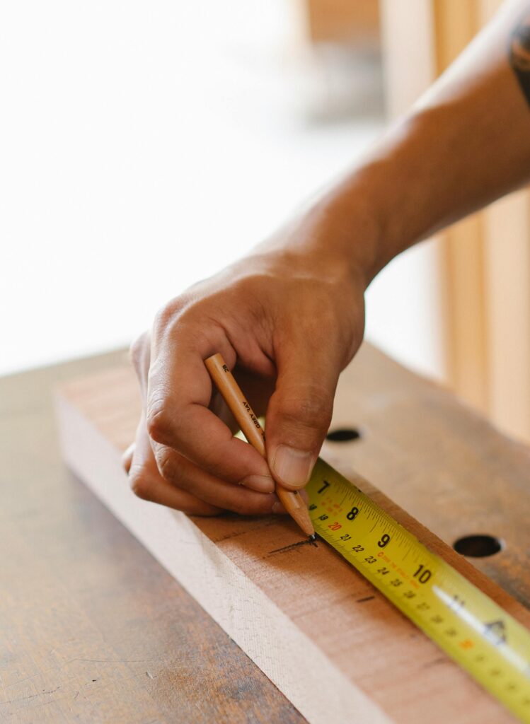professional carpenter measuring wooden joinery